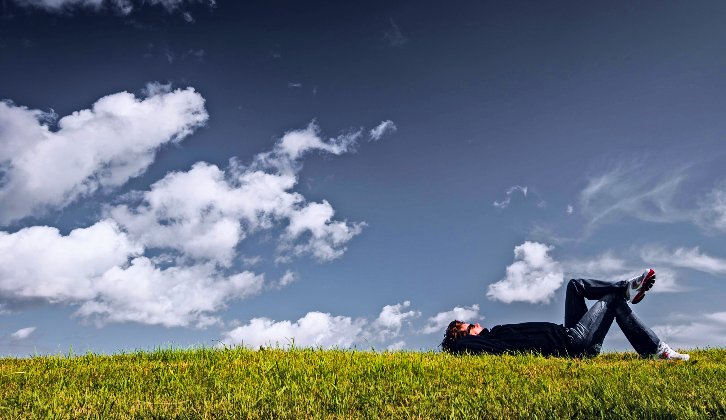 Person lying in a field illustrating a day of reset