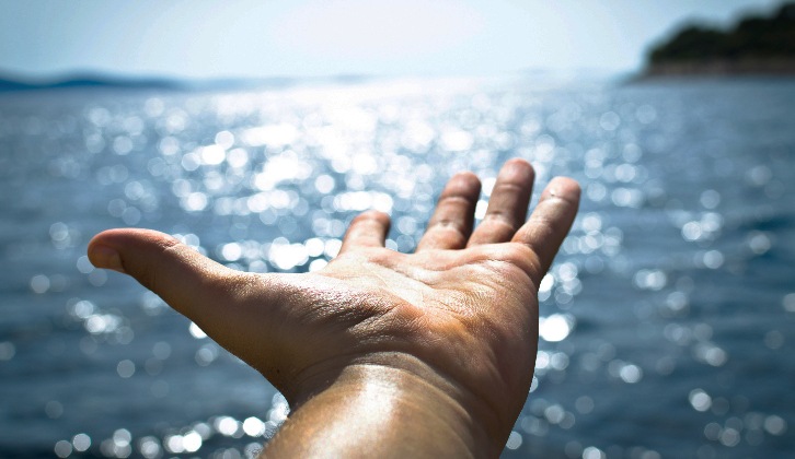 Commitments signaled with photo of a hand outstreched over open water
