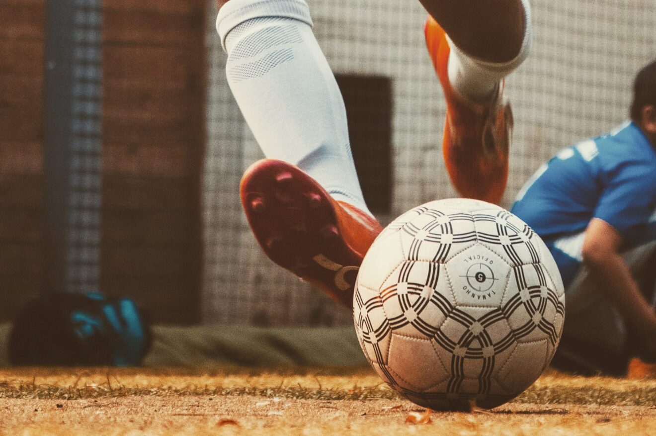 A person kicks a soccer ball.