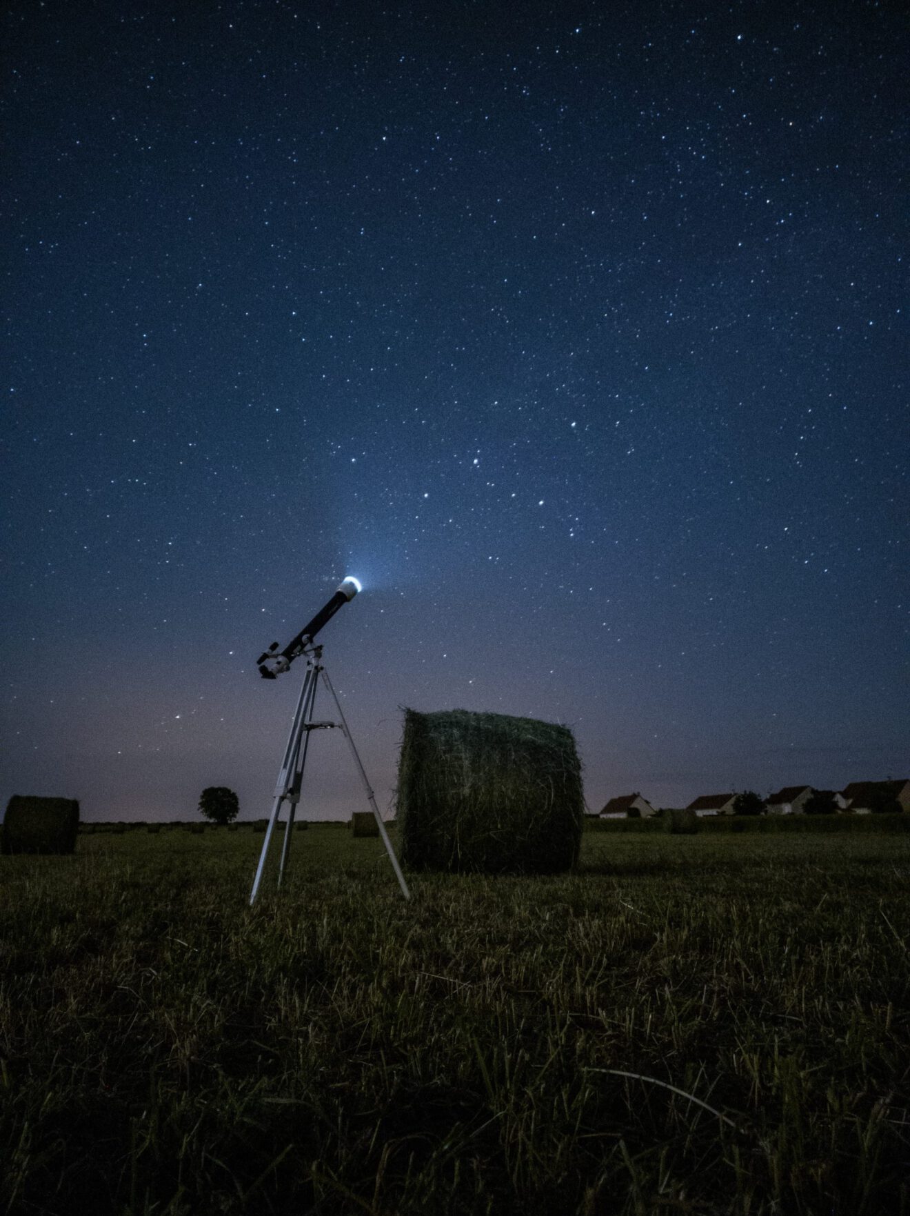 Landscape with telescope pointed toward night sky for space education article