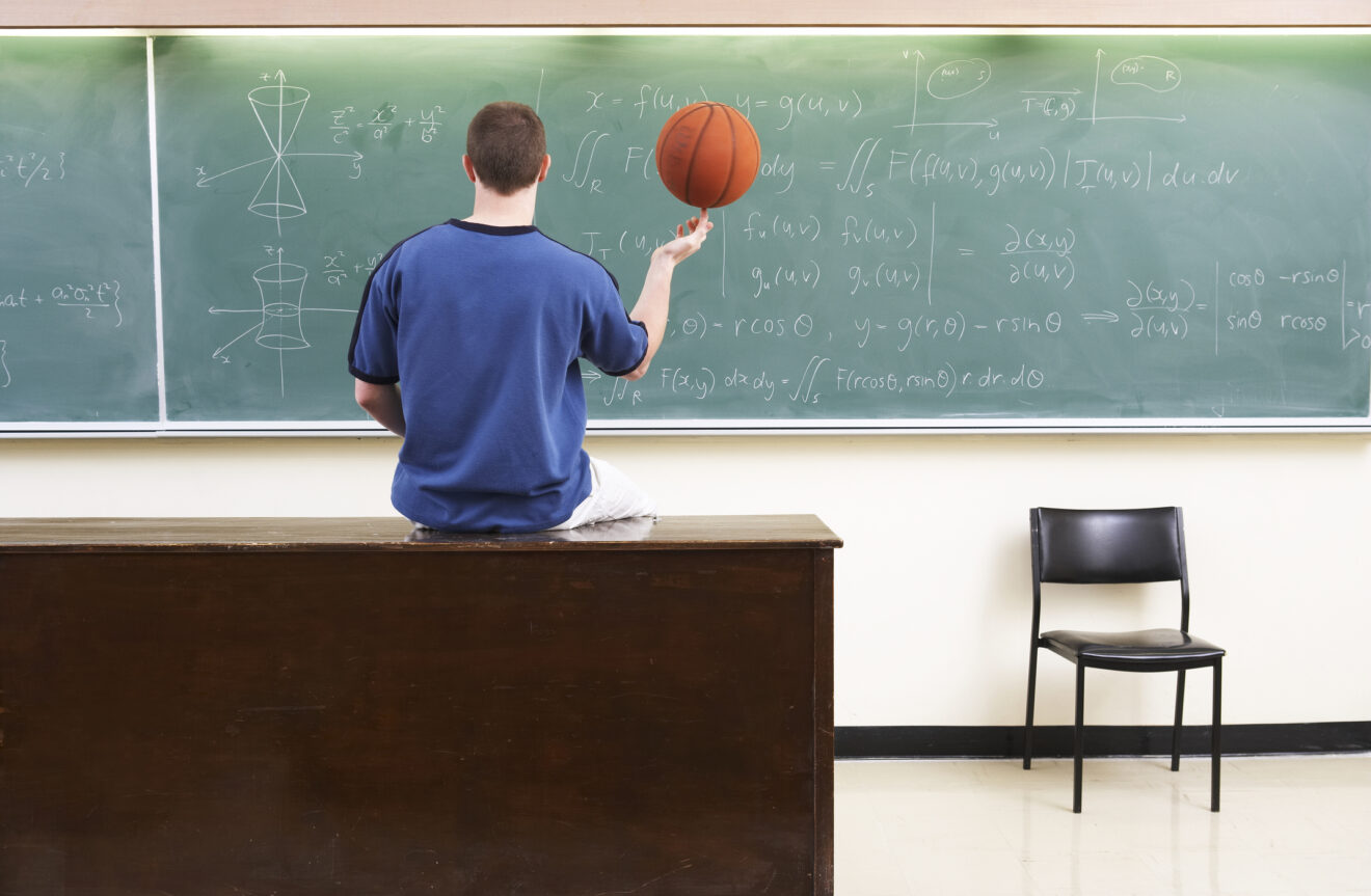Person holding basketball with fingertips facing a blackboard with advanced math for story on math people