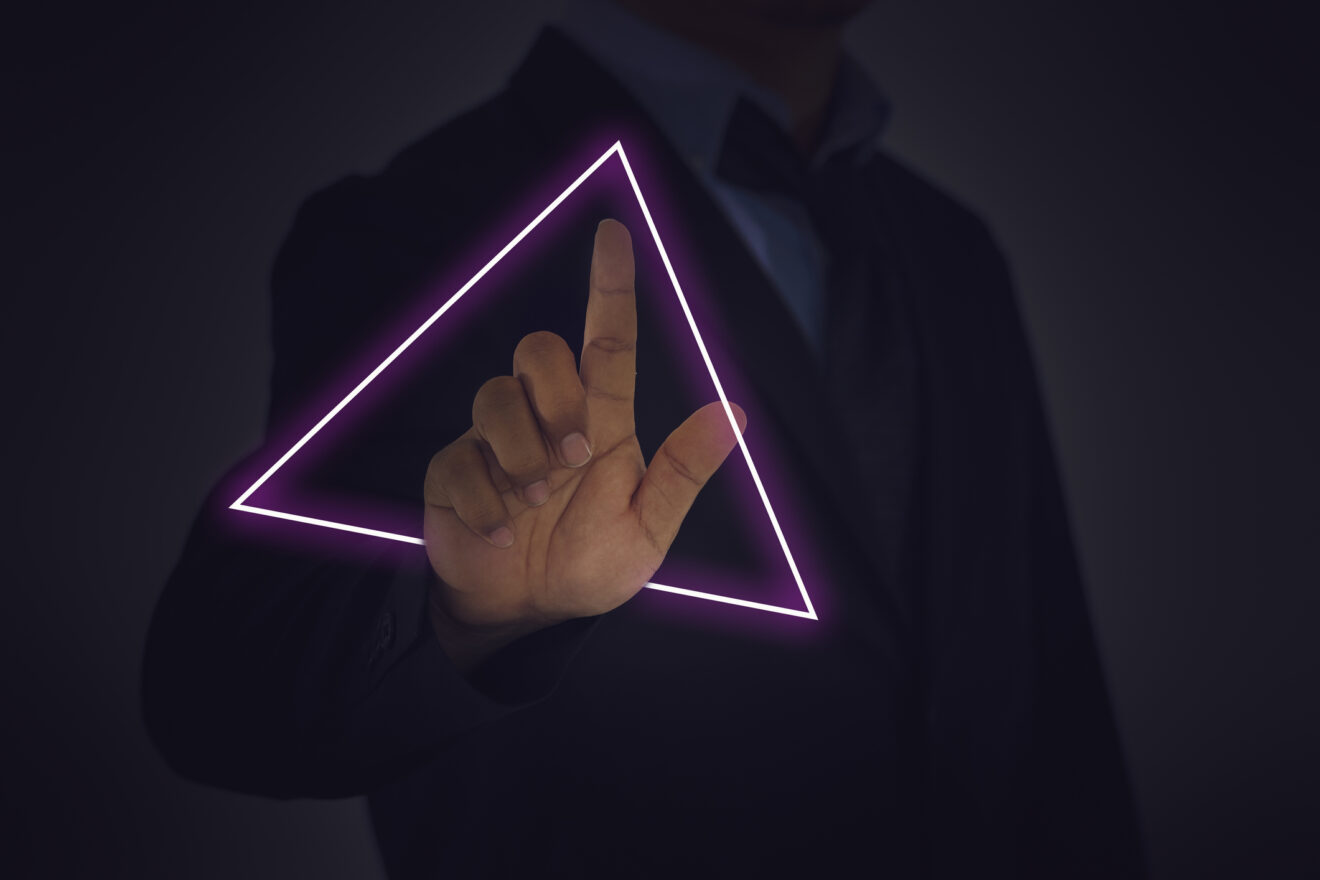 A businessman draws a neon light with his fingertips for article on triangle of success in education