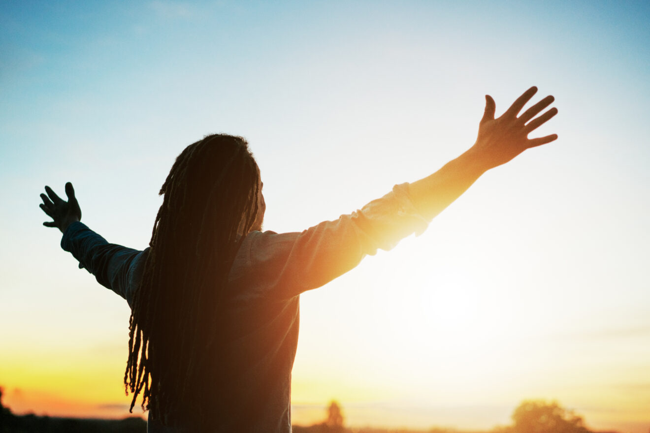 woman facing sun with arms spread wide for article on gratitude for educational leaders