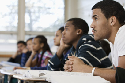 High-school or college students sitting at desks listening to teacher for article on storytelling in education