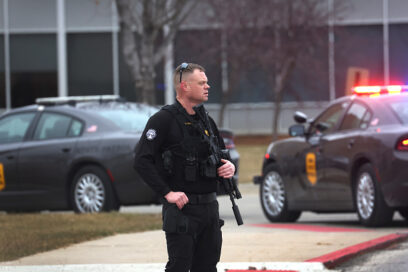 Police officer standing outside a school during a reported shooting in Iowa for article on school safety