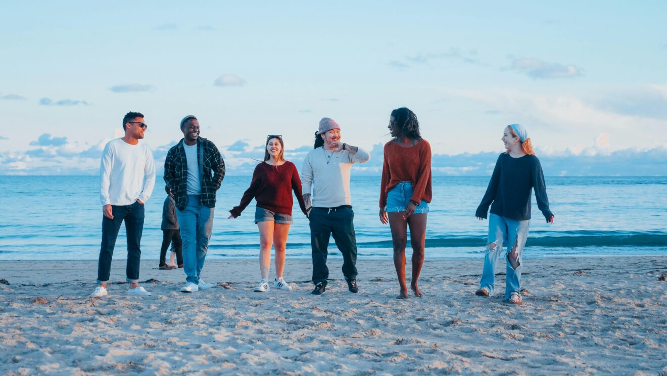 Scene of six young people from various cultures and races walking on a beach toward the viewer. Used on a story with headline as Best practices for multicultural marketing
