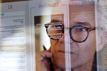 Close up stock photograph of a mature man studying a see-through computer monitor that’s displaying text provided by an AI (artificial intelligence) chatbot. for article on AI edtech tools