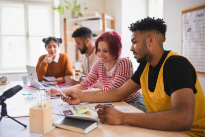 Group of Generation Z / young people sitting at the desk at work, brainstorming.