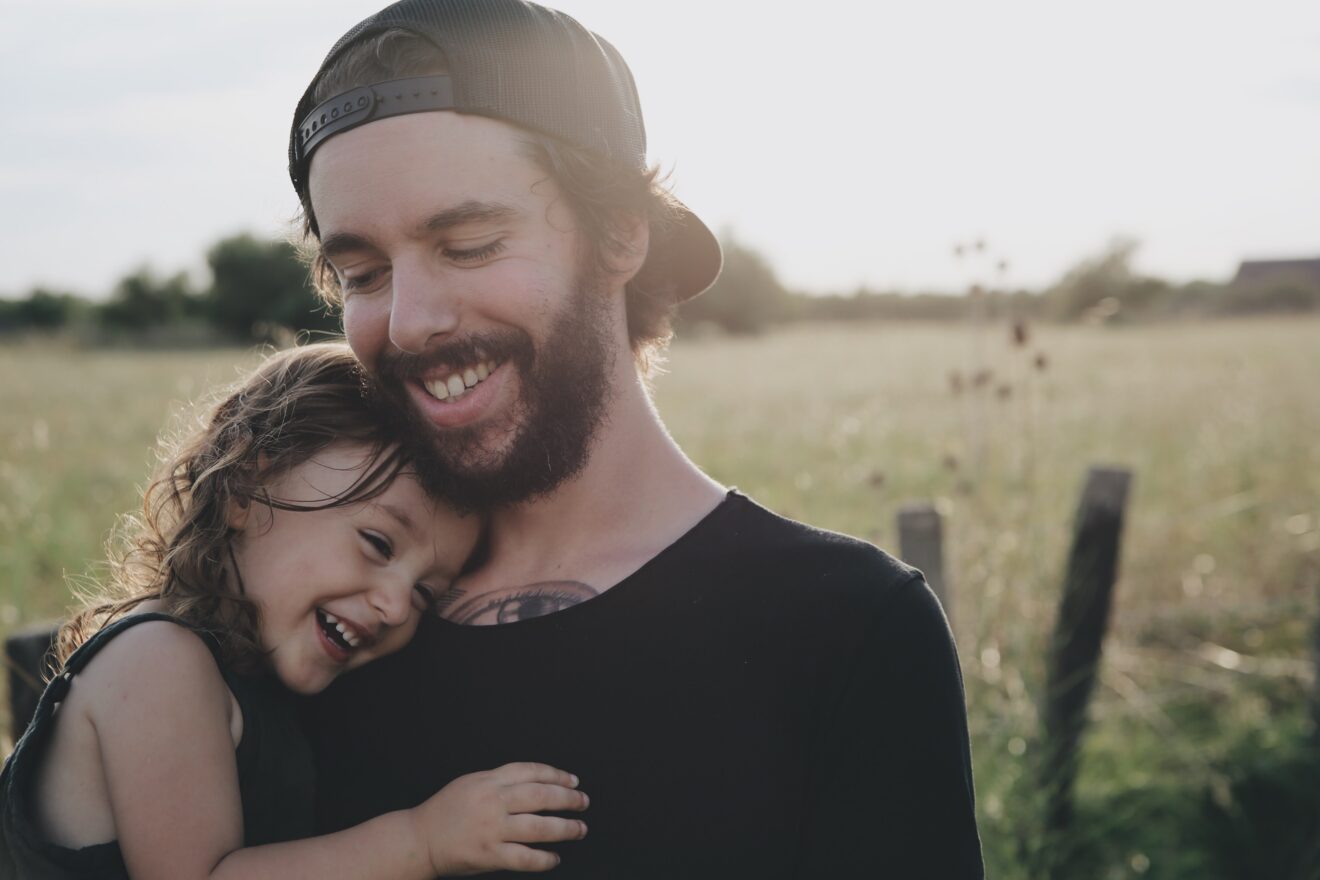 A photo of a dad with tattoos and his daughter
