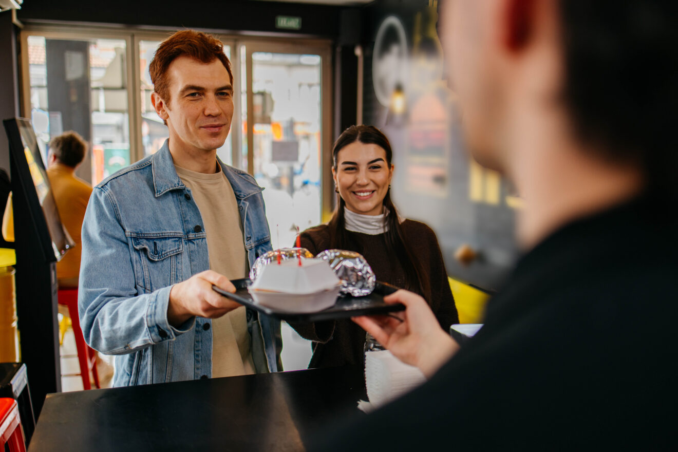 Couple picking up food at the counter in a fast food restaurant