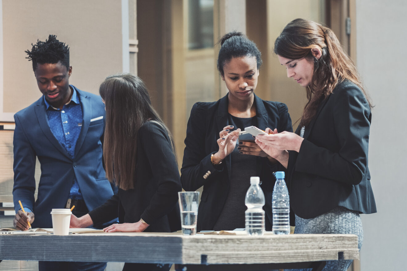 Group of creative business people standing behind the desk. Used for SmartBrief Original with headline: How brands are combating AI fatigue with in-person events