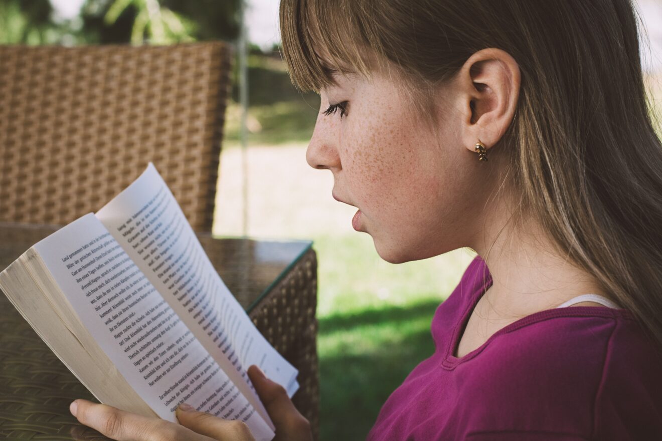 A teenage girl reading a book.