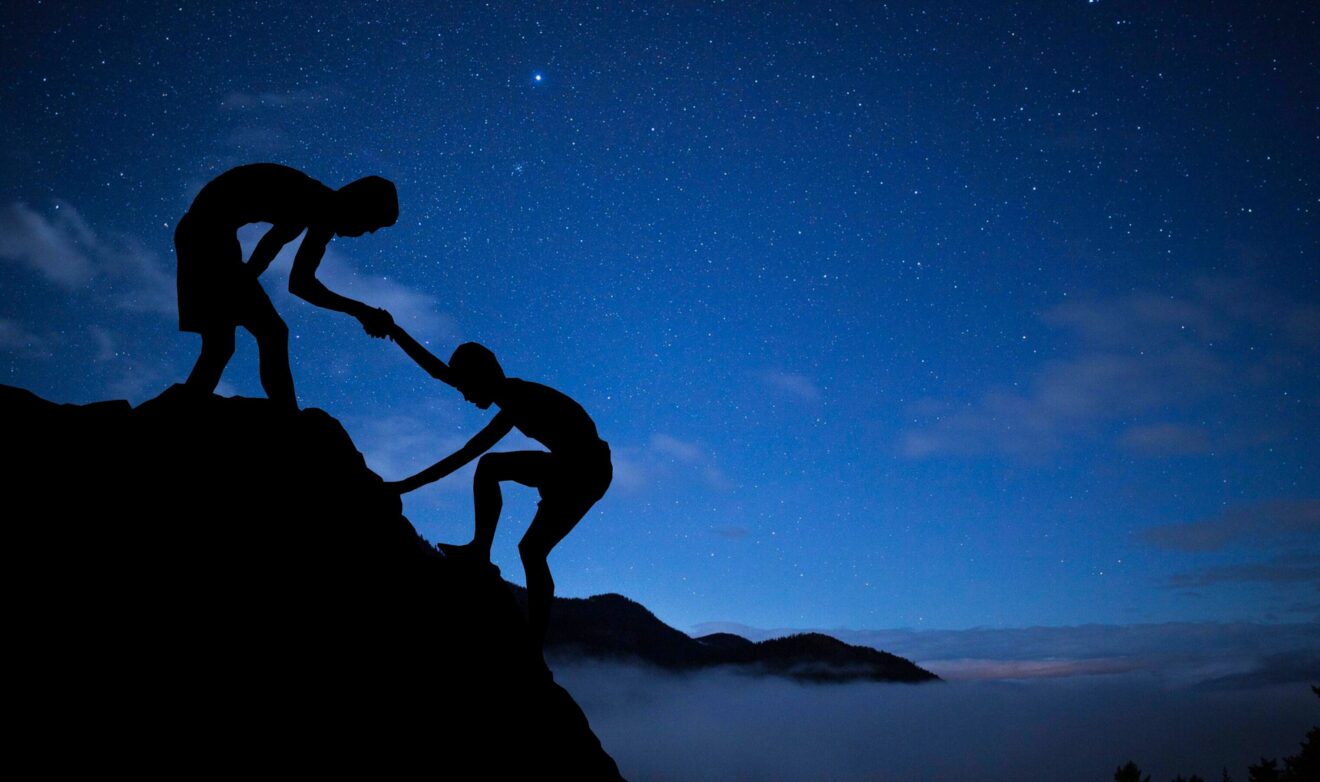 A helping hand climbing up a mountain.